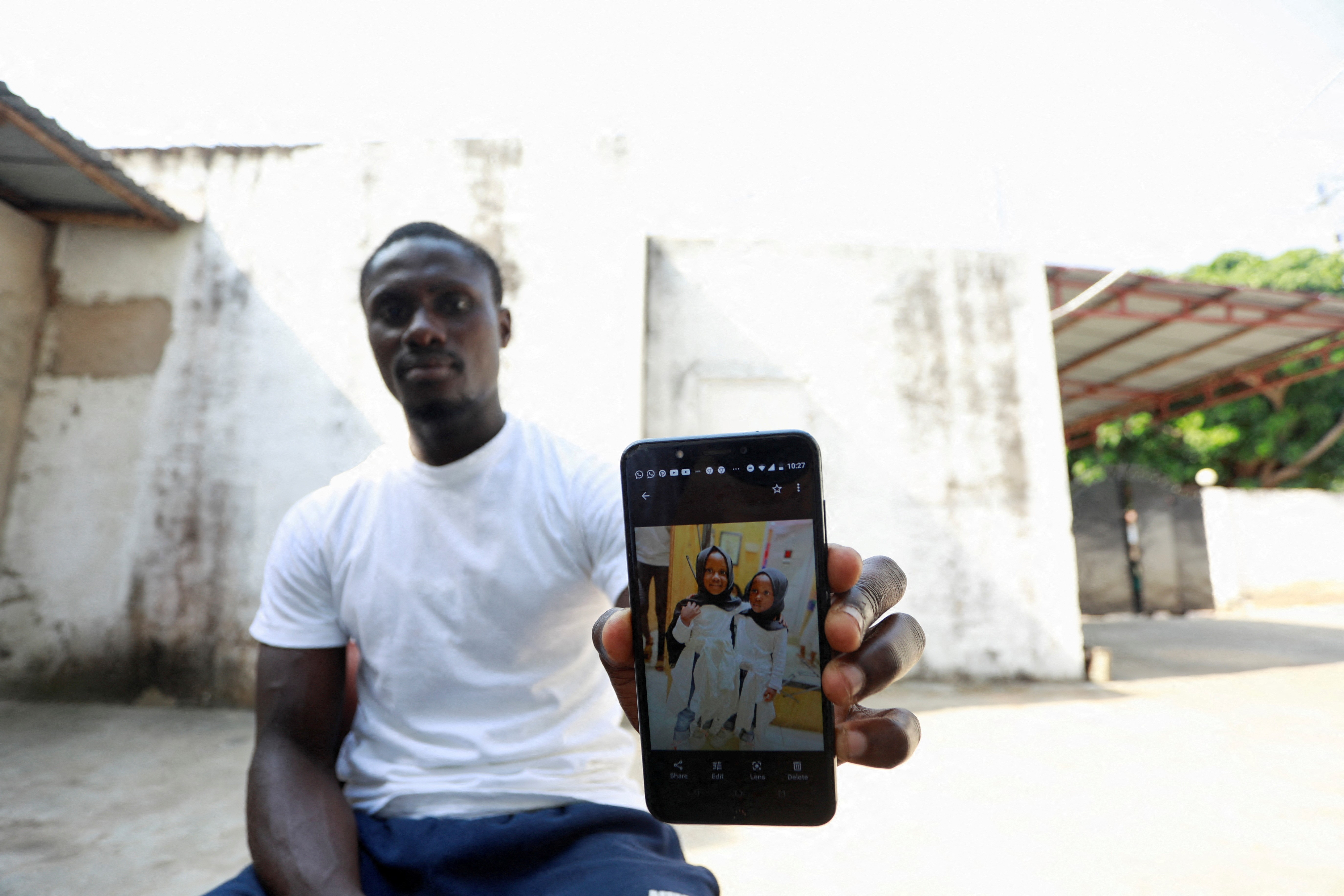 Ebrima Saidy shows a picture on his phone of his twin daughters, one of whom, Adama, 3, died of Acute Kidney Injury in September 2022, in Tanji, Gambia, November 3, 2022. Photo: Reuters