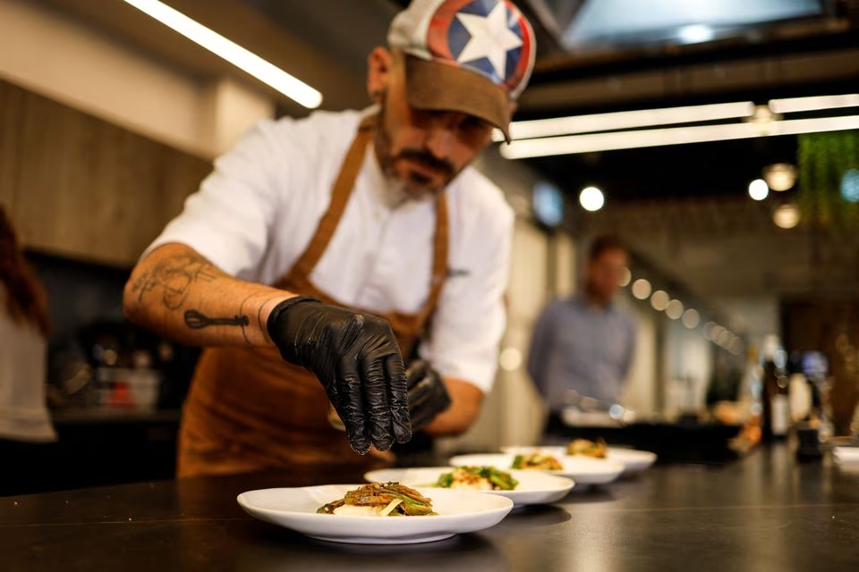 A chef prepares a dish with pieces of 3D-printed cultivated grouper fish for a tasting at the offices of Steakholder Foods in Rehovot, Israel, April 23, 2023. Photo: Reuters