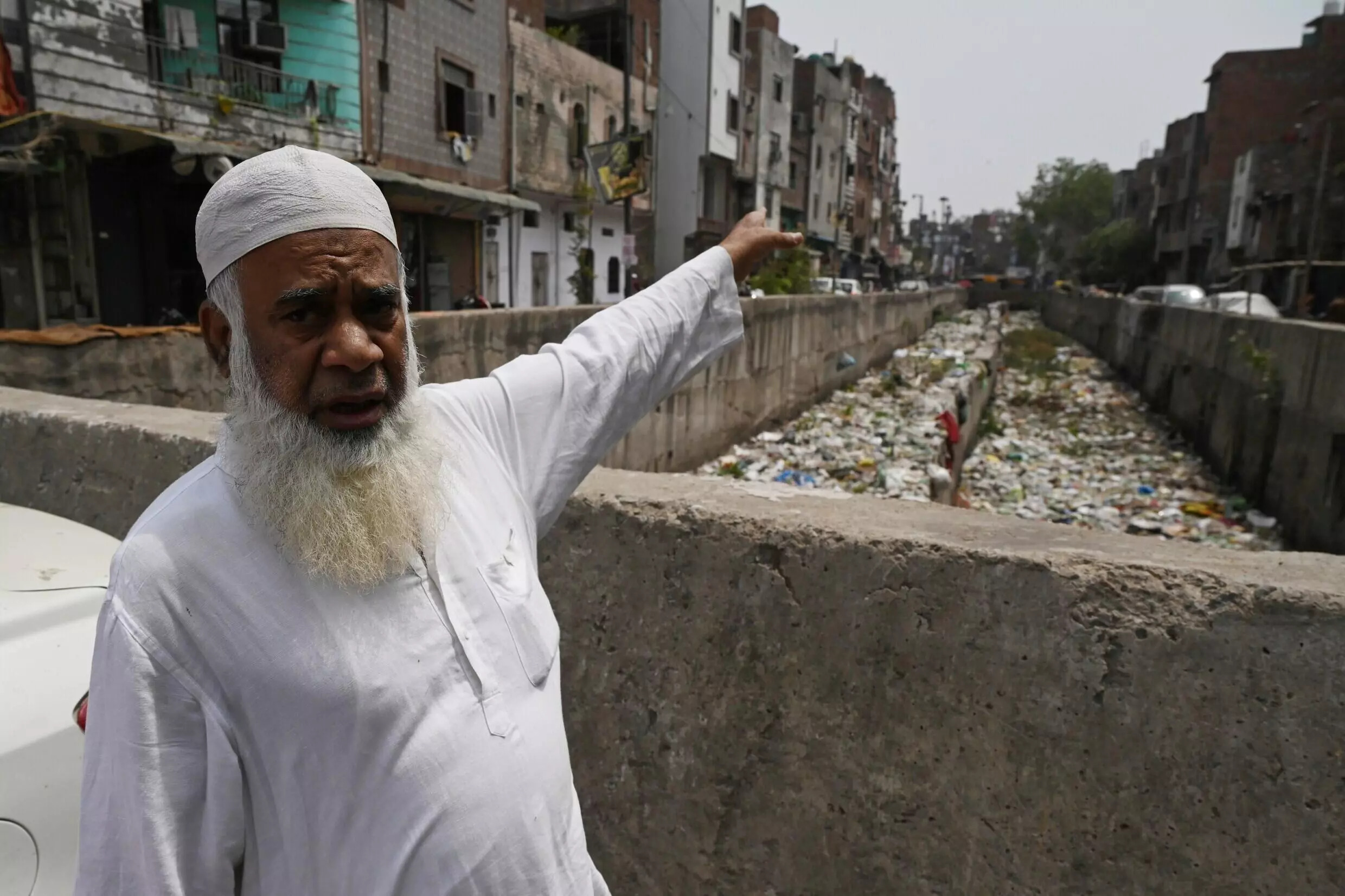 Khalil Ahmad, a resident of New Delhi's Seelampur neighbourhood, gestures towards a sewage canal filled with garbage during a interview with AFP. Photo: AFP