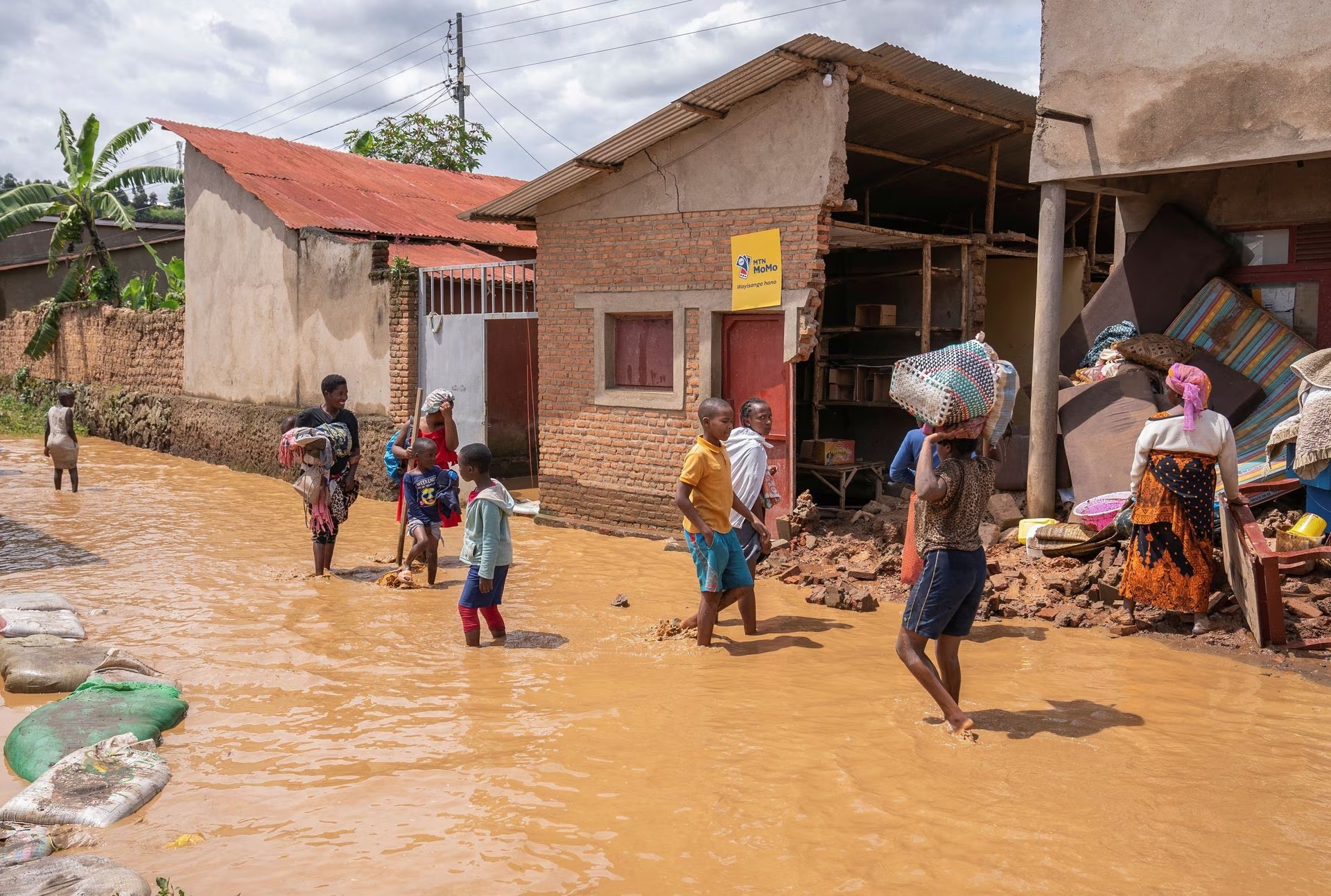 Residents wade through water after their homes were swamped, following rains that triggered flooding and landslides in Rubavu district, Western province, Rwanda May 3, 2023. Photo: Reuters