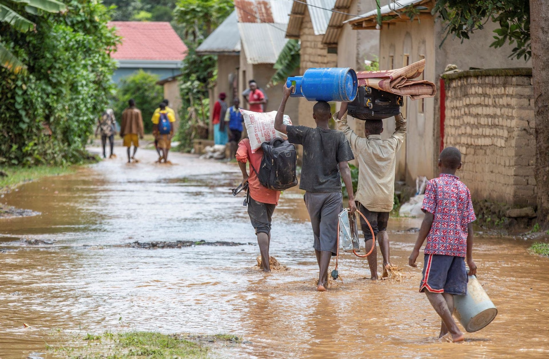 Residents wade through water after their homes were swamped following rains that triggered flooding and landslides in Rubavu district, Western province, Rwanda May 3, 2023. Photo: Reuters