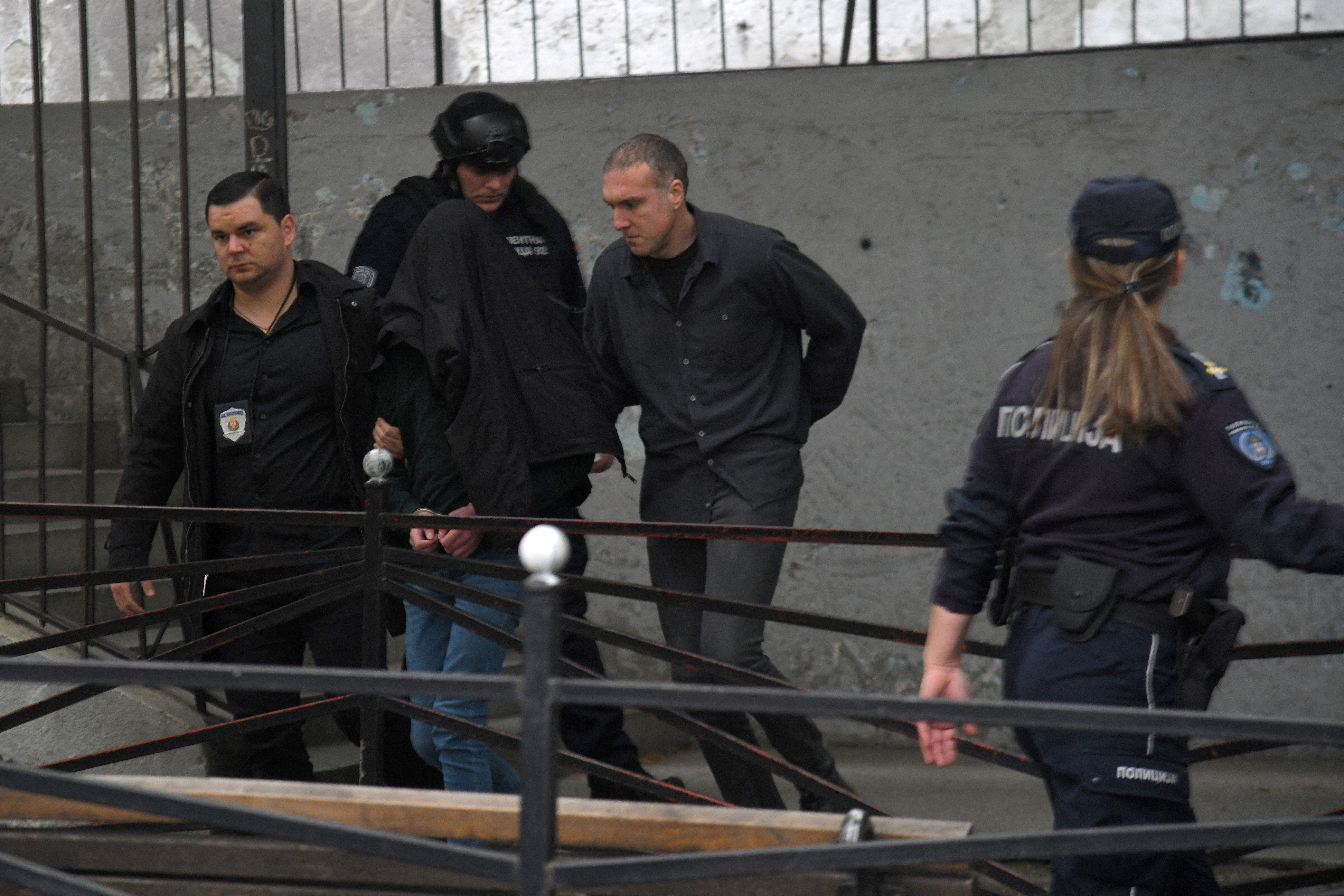 Police officers walk with a shooting suspect out of school after he opened fire on other students and staff at a school in downtown Belgrade, Serbia, May 3, 2023. Photo: Reuters