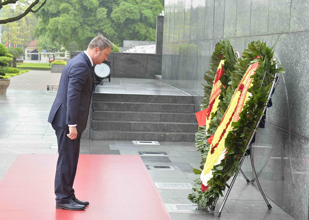 Prime Minister of Luxembourg Xavier Bettel bends his head and pays his tribute to late President Ho Chi Minh. Photo: Vietnam News Agency