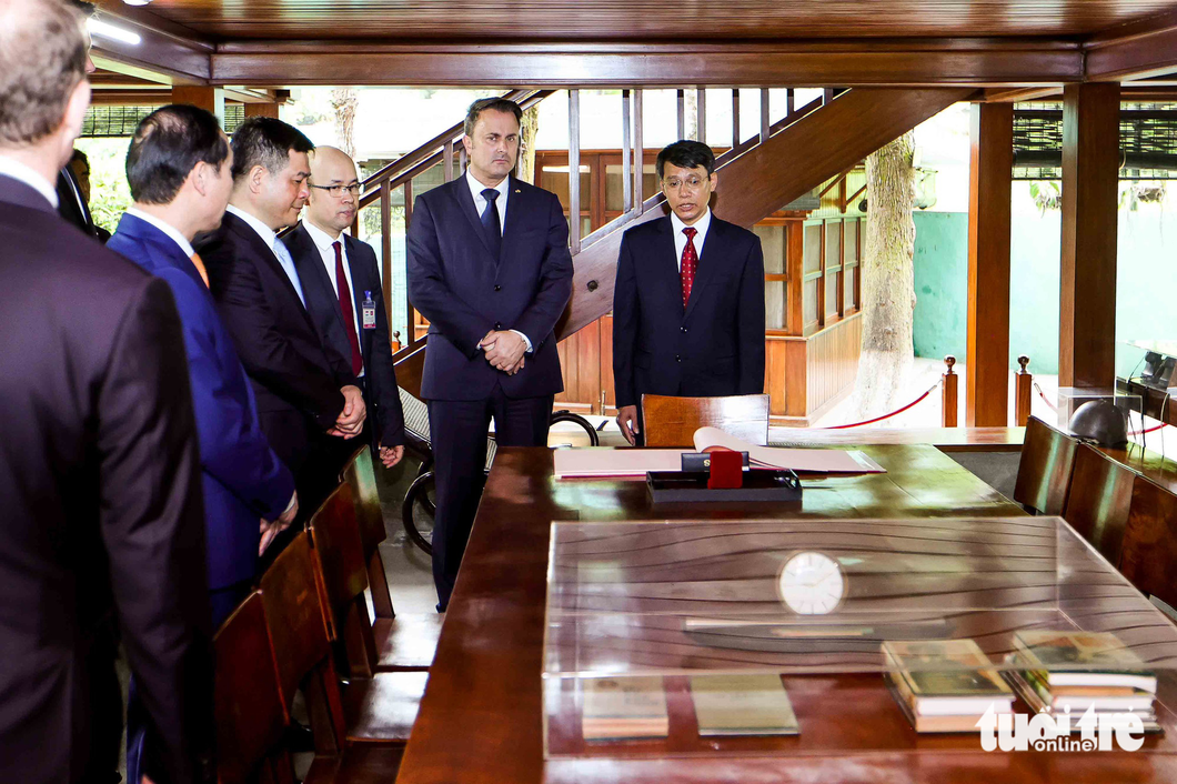 Prime Minister of Luxembourg Xavier Bettel listens to the introduction to the stilt house of late President Ho Chi Minh. Photo: Nguyen Khanh / Tuoi Tre