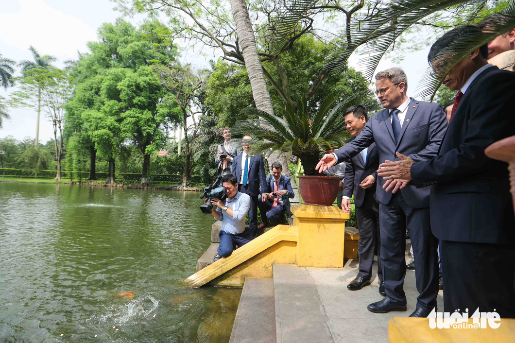 Prime Minister of Luxembourg Xavier Bettel makes a stop at a fish lake, one of the highlights of the Presidential Palace Historical Site. Photo: Nguyen Khanh / Tuoi Tre