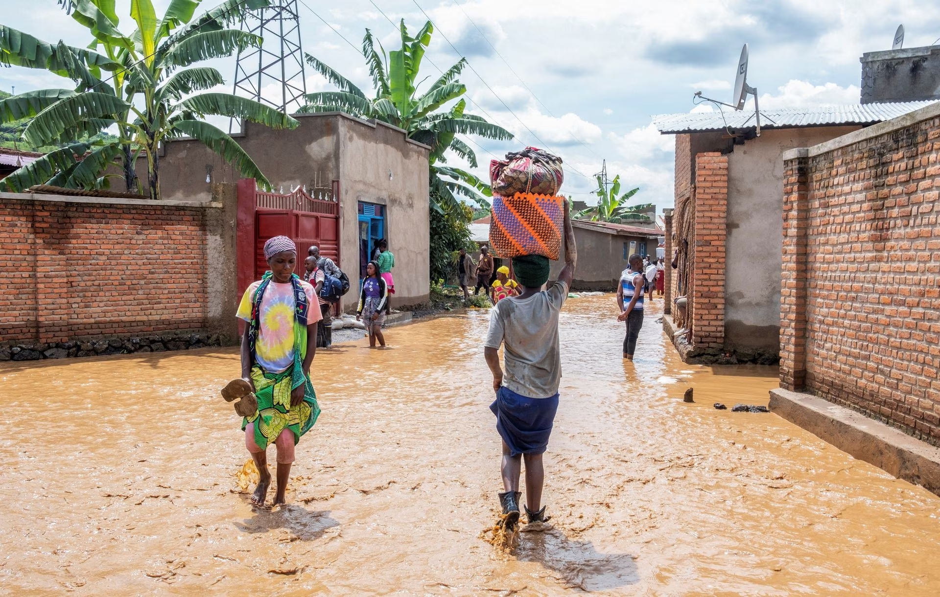 Residents wade through water after their homes were swamped following rains that triggered flooding and landslides in Rubavu district, Western province, Rwanda May 3, 2023. Photo: Reuters