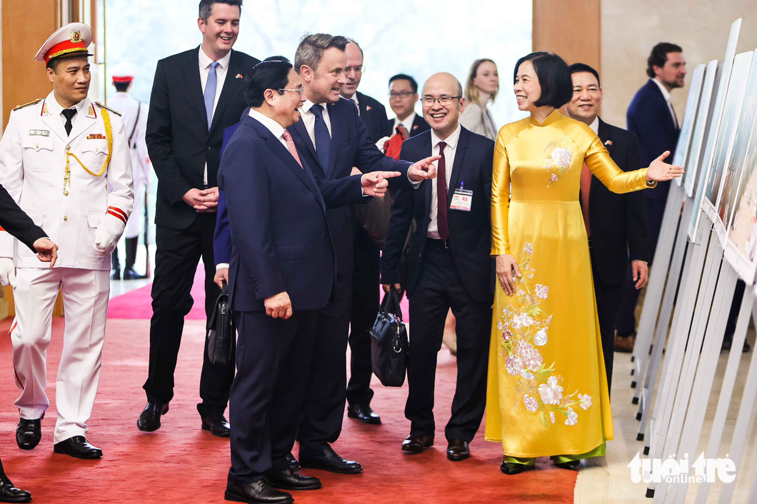 Vietnamese Prime Minister Pham Minh Chinh and Prime Minister of Luxembourg Xavier Bettel take a look at some photos at a photo exhibition to celebrate 50 years of bilateral ties. Photo: Nguyen Khanh / Tuoi Tre