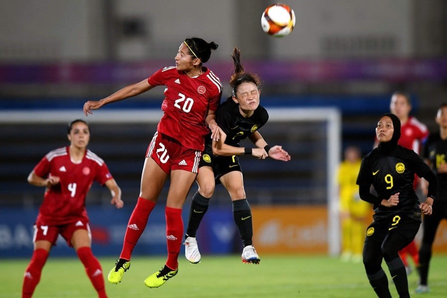 Quinley Quezada of Philippines fight for the ball with Malaysia's Jaciah Jumlis in their women's football group match during the 32nd Southeast Asian Games (SEA Games) at the Army Stadium in Phnom Penh. Photo: AFP