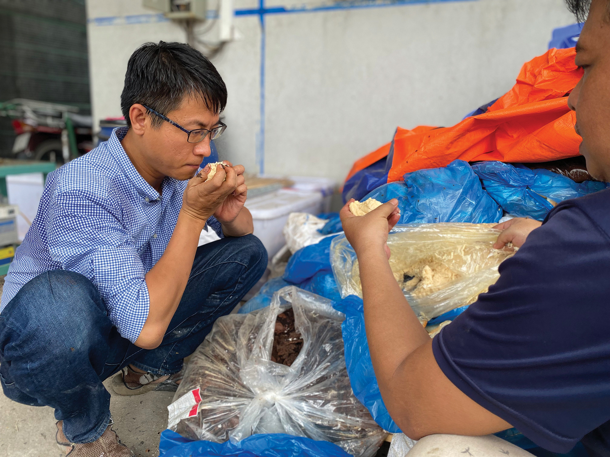 Huynh Hanh Phuc checks the quality of waste before recycling it in his farm.