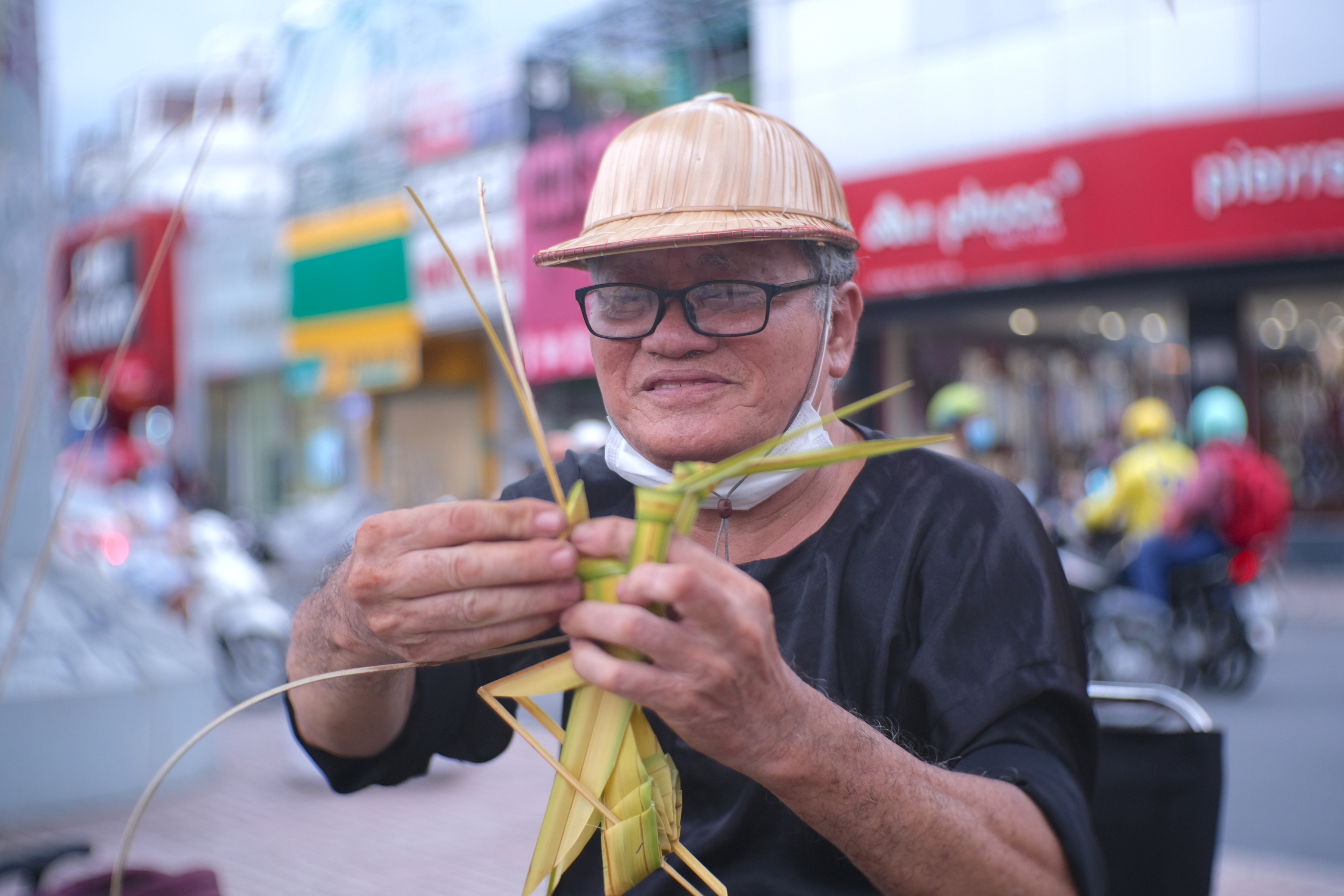 Le Minh, 70, makes a locust from mangrove palm leaf on the street in Ho Chi Minh CIty. Photo: Ngoc Phuong / Tuoi Tre News