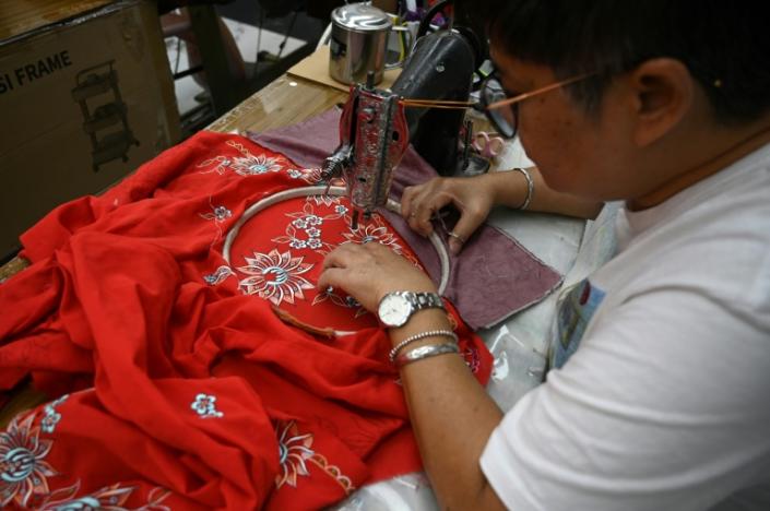 This picture taken on April 7, 2023 shows a worker sewing a kebaya, a traditional outfit worn by women in Southeast Asia, for sale at a shop in Kuala Lumpur. Photo: AFP