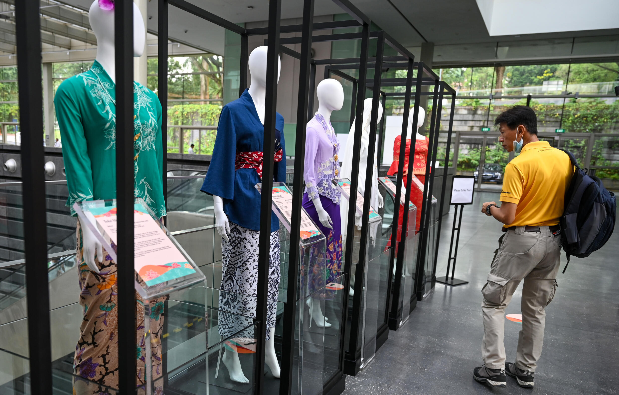 A man looks at displays of the kebaya, a traditional outfit worn by women in Southeast Asia, at the National Museum in Singapore on April 5, 2023. Photo: AFP