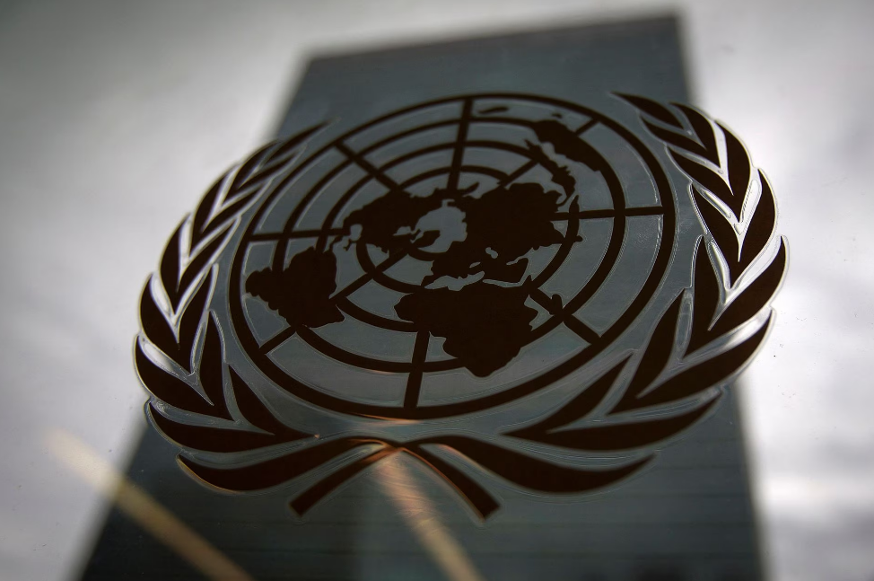 The United Nations headquarters building is pictured though a window with the UN logo in the foreground in the Manhattan borough of New York August 15, 2014. Photo: Reuters