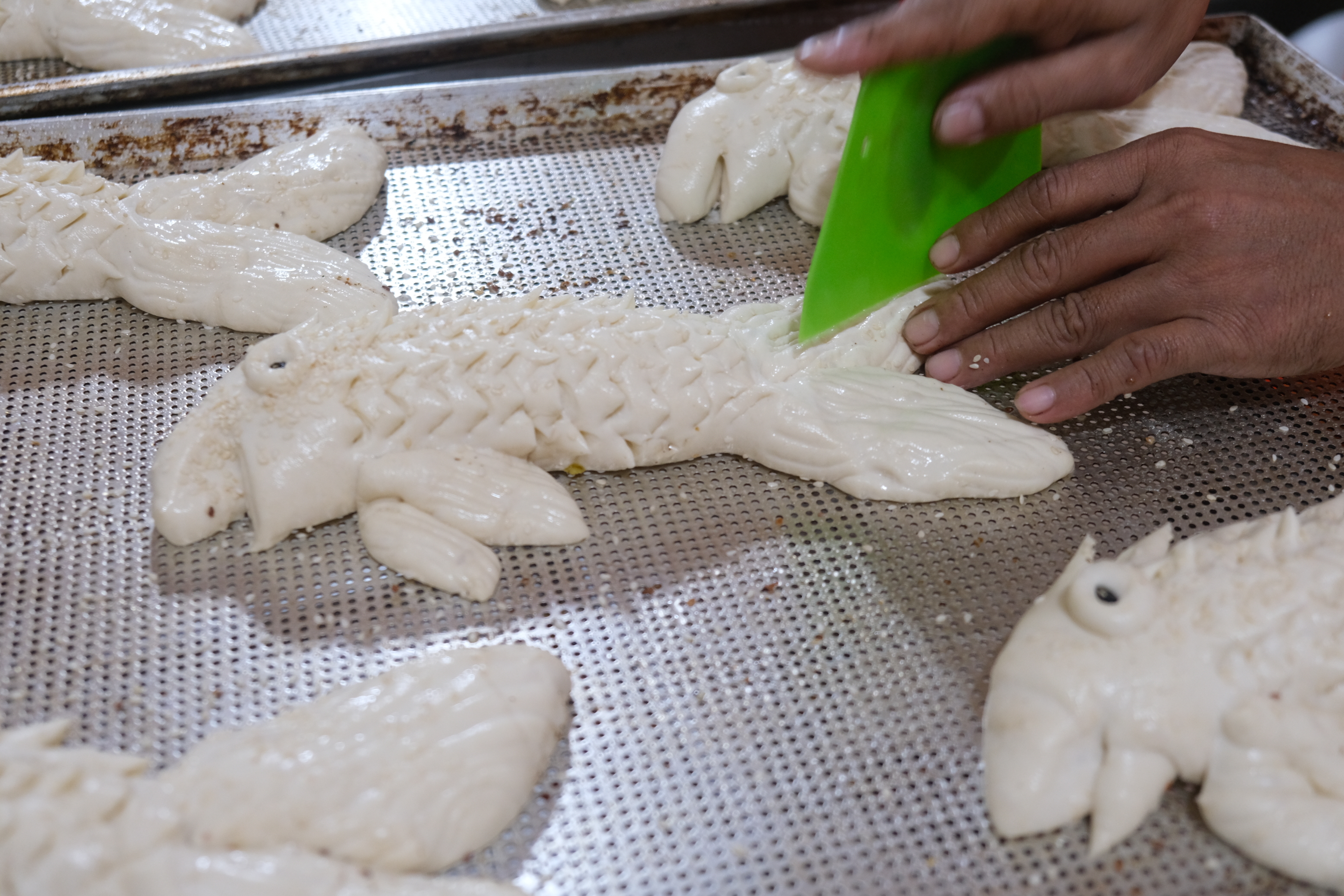 A staff members shapes bread into fish at 7.7 Bakery. Photo: Ngoc Phuong / Tuoi Tre News