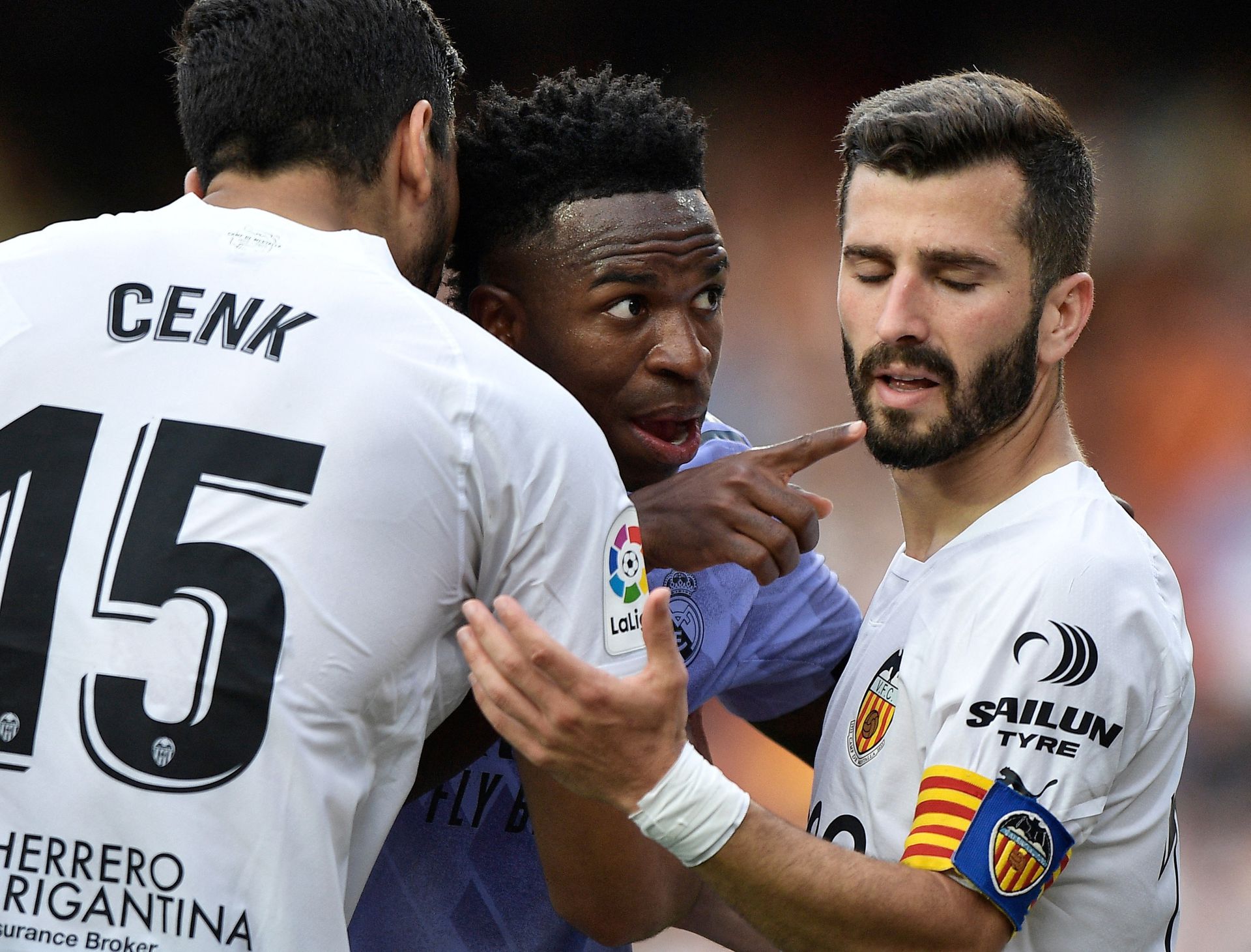 Soccer Football - LaLiga - Valencia v Real Madrid - Mestalla, Valencia, Spain - May 21, 2023 Real Madrid's Vinicius Junior gestures towards a fan after witnessing abuse as Valencia's Jose Gaya and Cenk Ozkacar attempt to restrain him. Photo: Reuters