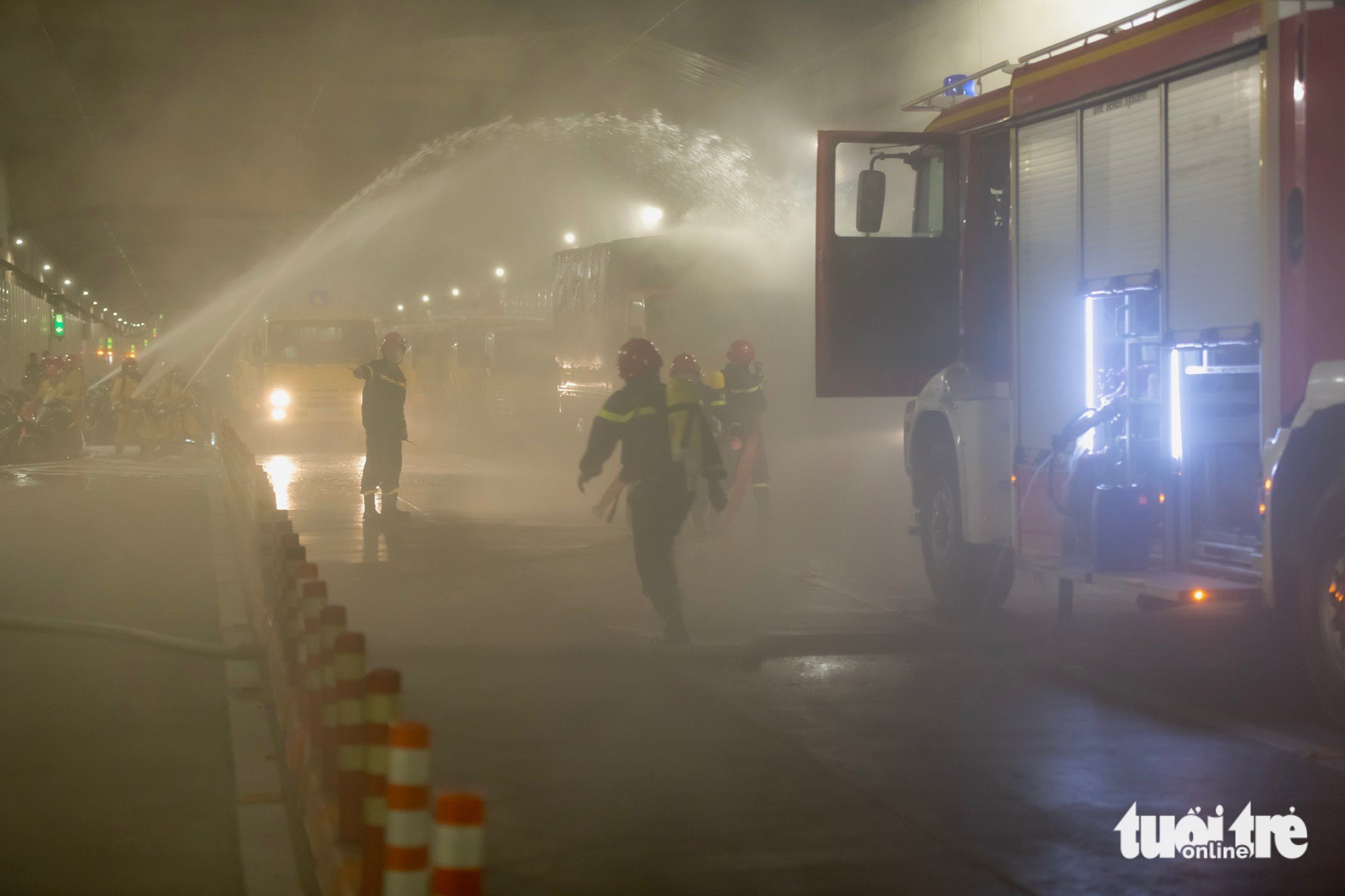 Firefighters spray water to extinguish the fire inside the Saigon River Tunnel. Photo: Minh Hoa / Tuoi Tre