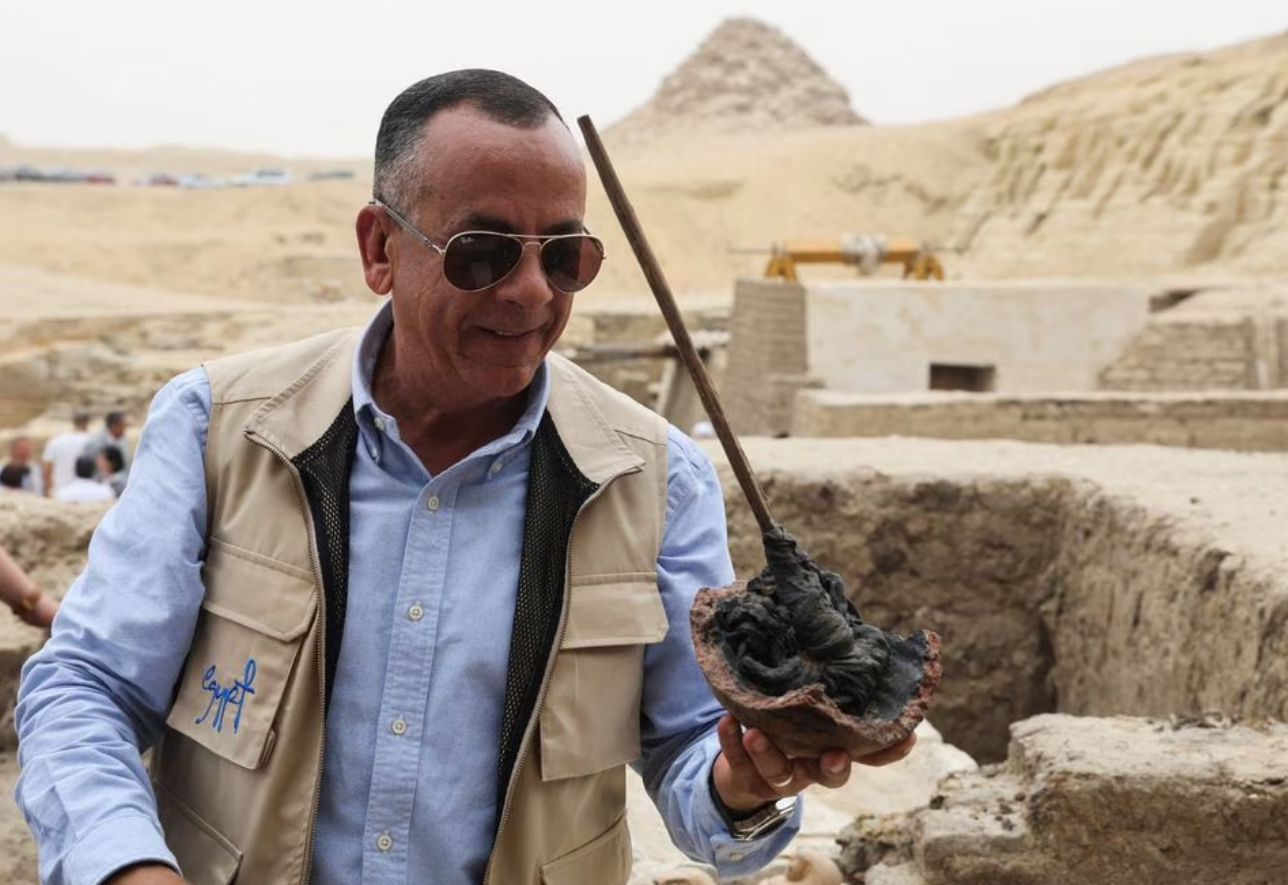 Mostafa Waziri, secretary-general of Egypt's Supreme Council of Antiquities talks to the media and holds a tool that was found next to an embalming workshop site for humans at the newly discovered site where embalming workshops for humans and animals along with two tombs and a collection of artefacts were also found, near Egypt's Saqqara necropolis, in Giza, Egypt May 27, 2023. Photo: Reuters