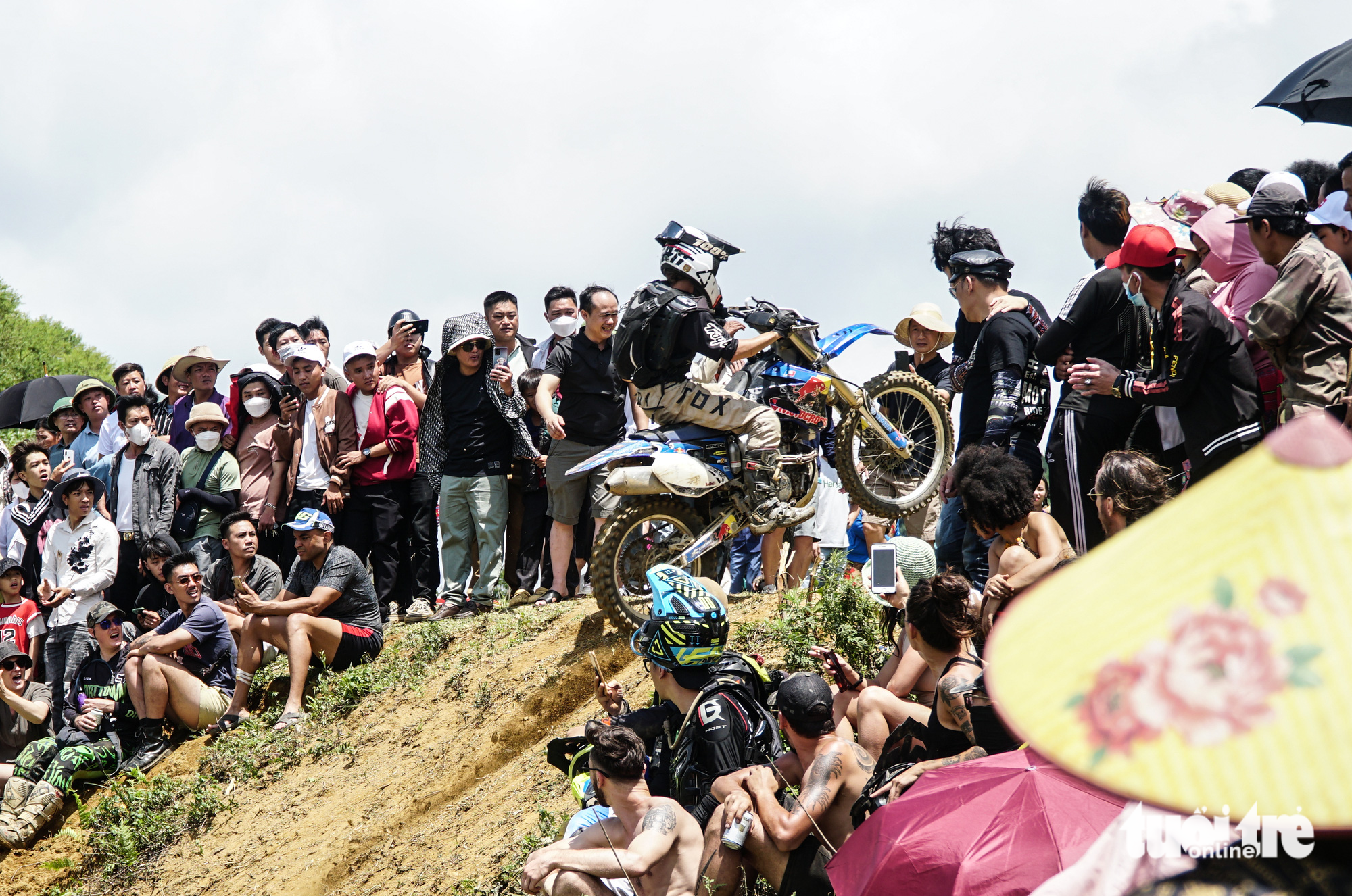 Spectators watch a rider racing in the final race of the 2023 VTV Cab - Off road motorcycle racing tournament in Van Ho District, Son La Province, Vietnam, May 28, 2023. Photo: Nguyen Hien / Tuoi Tre