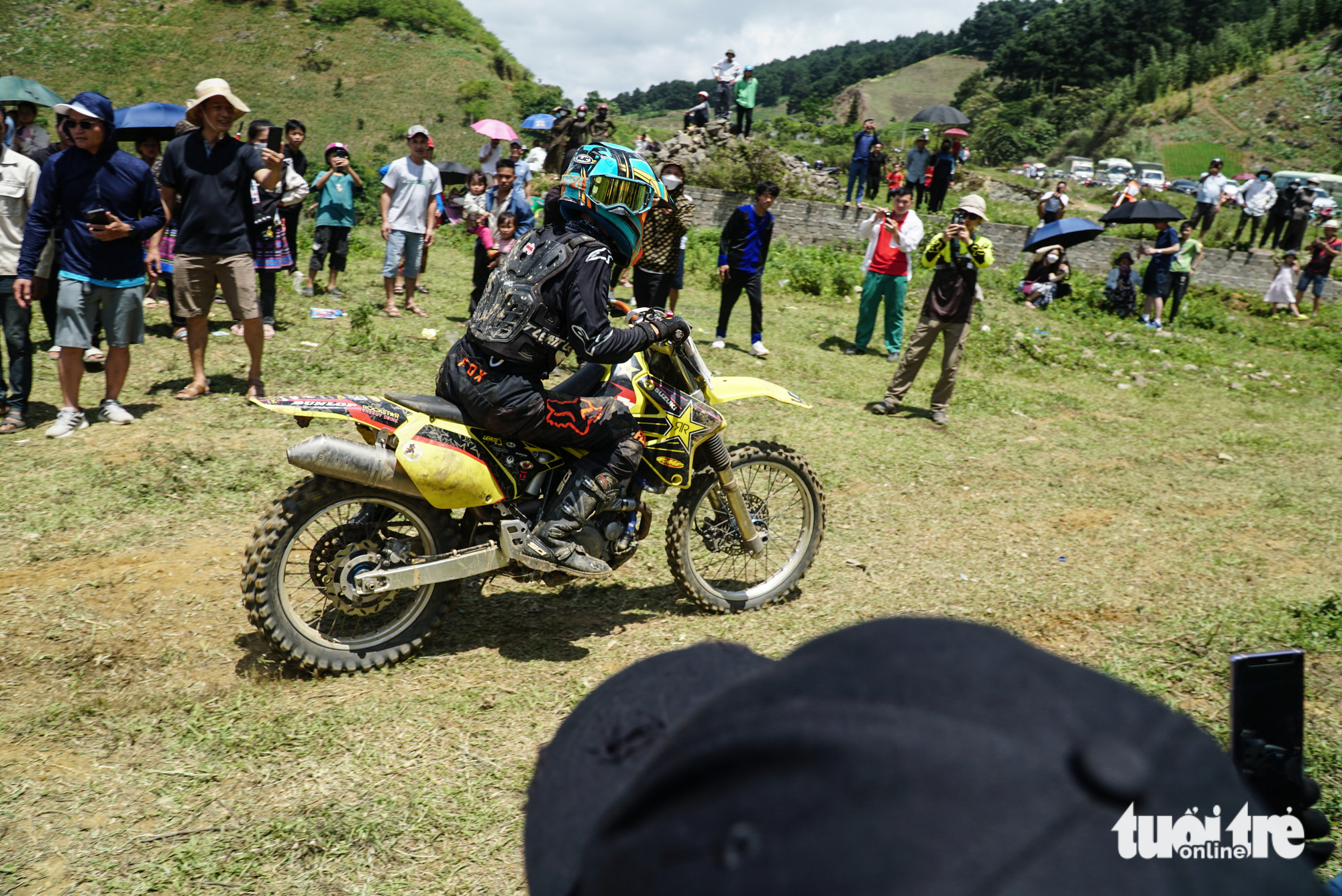 Spectators watch a rider racing in the final race of the 2023 VTV Cab - Off-road motorcycle racing tournament in Van Ho District, Son La Province, Vietnam, May 28, 2023. Photo: Nguyen Hien / Tuoi Tre