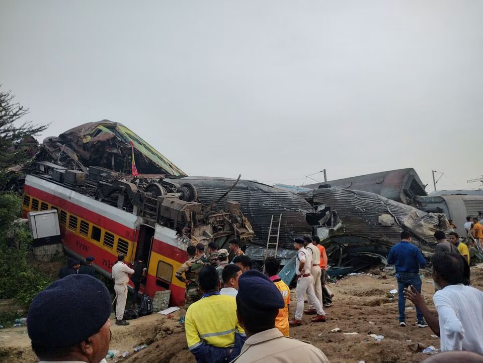 Onlookers and rescue workers stand next to damaged coaches, after trains collided in Balasore, India June 3, 2023, in this picture obtained from social media. Photo: Reuters