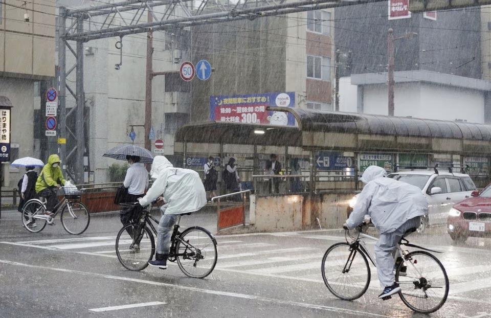 People riding bicycles make their way in the heavy rain in Kochi, Kochi Prefecture, Japan June 2, 2023, in this photo taken by Kyodo. Mandatory credit Kyodo via Reuters