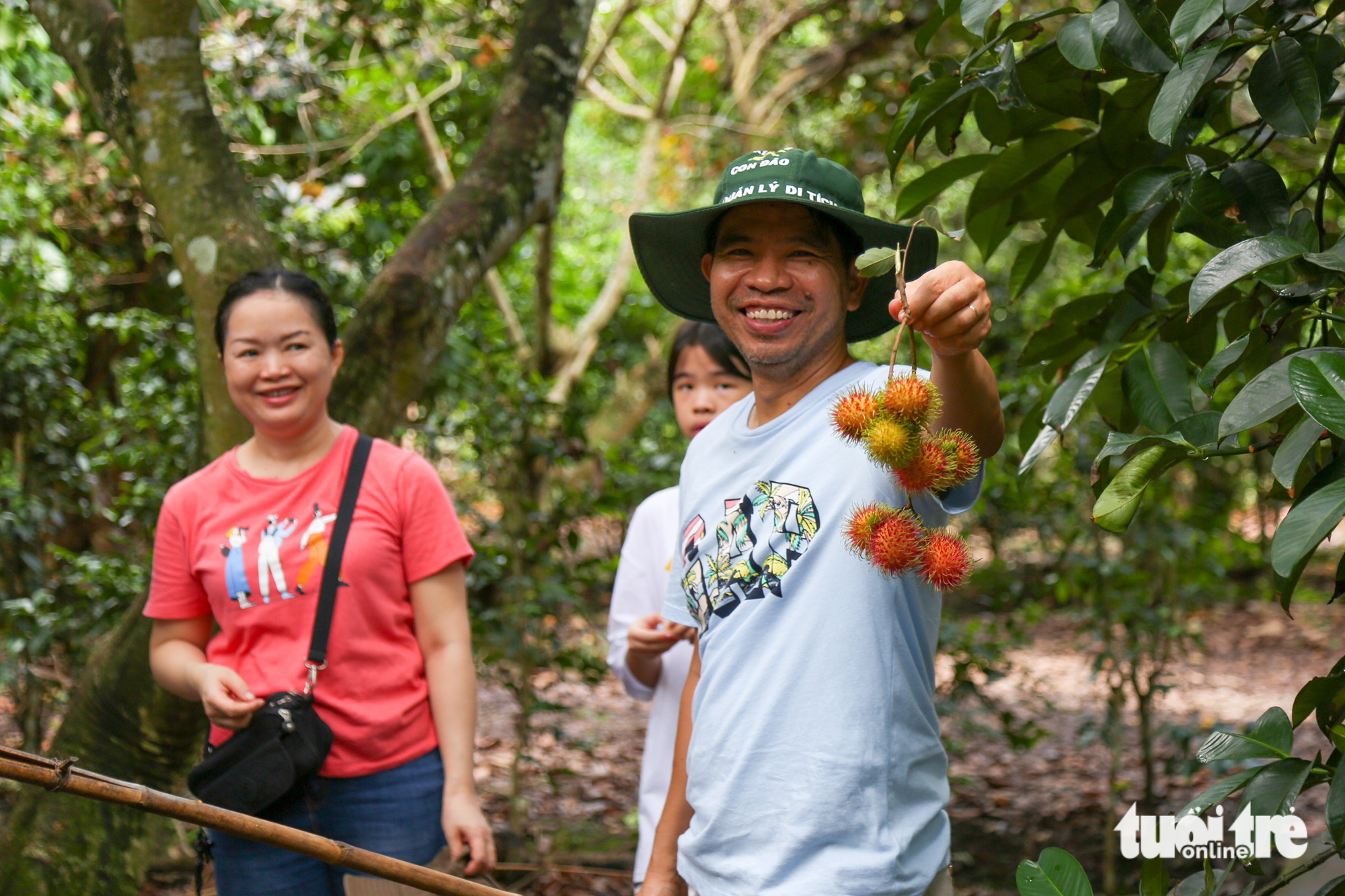 Nguyen Canh Toan (R) and his family harvest rambutans during a program offering visitors countryside experiences in Trung An Commune, Cu Chi District, Ho Chi Minh City, June 3, 2023. Photo: Tuoi Tre