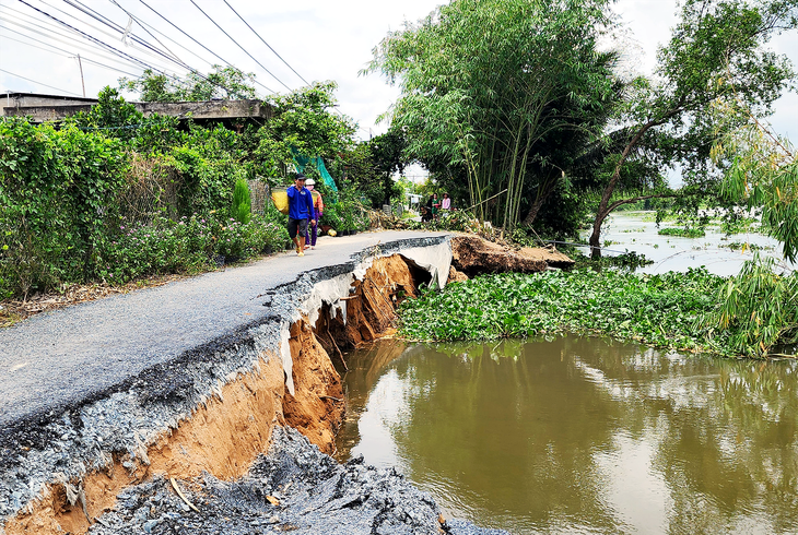 A 50-meter road section along the Ba Rai River in Hoi Xuan Commune, Cai Lay District, Tien Giang Province sinks into the river. Photo: Hoai Thuong / Tuoi Tre