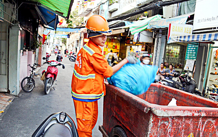 An employee collects garbage in Alley 391 on Tran Hung Dao Street, District 1, Ho Chi Minh City. Photo: Phuong Quyen / Tuoi Tre