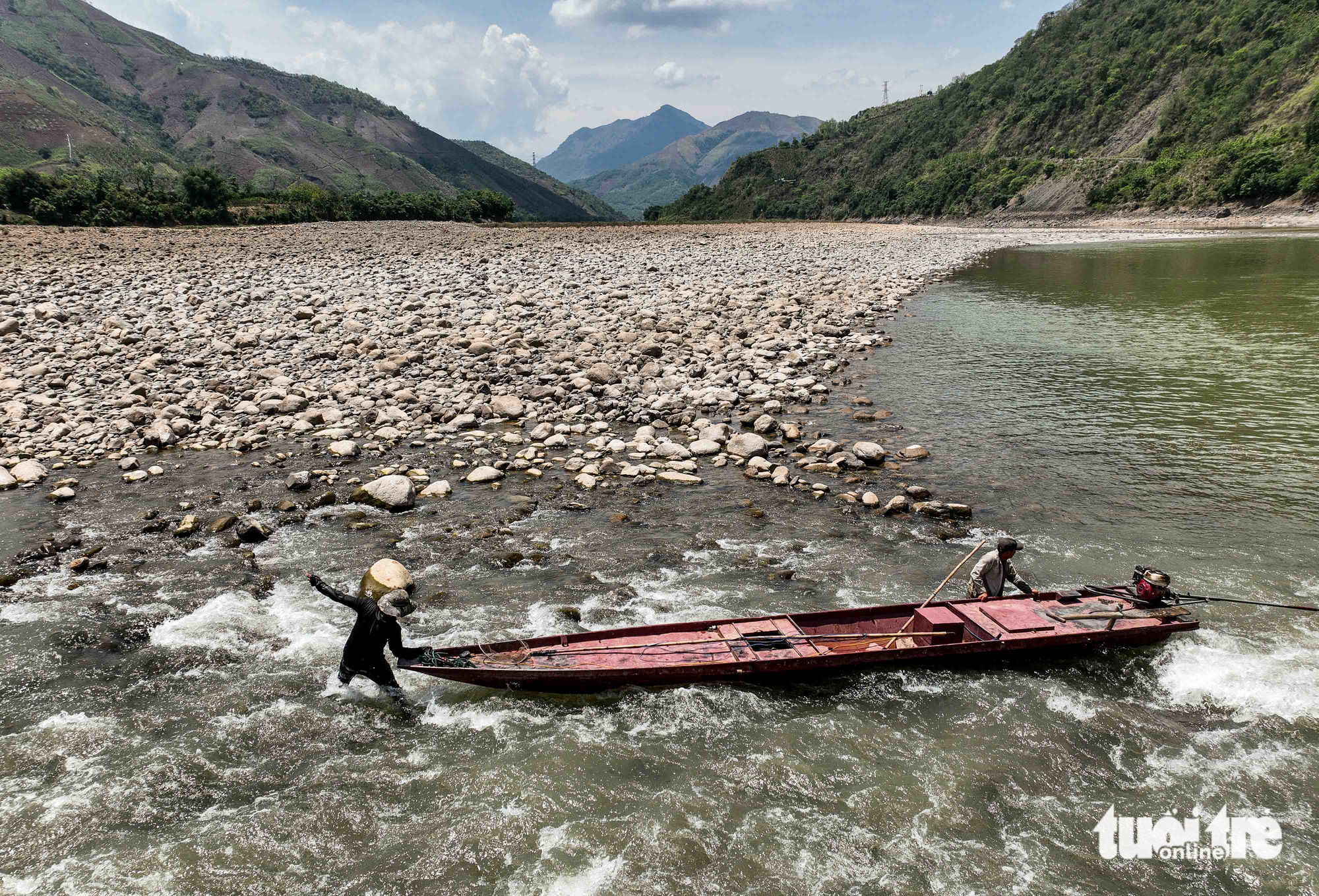 Two local men pull their boat at a Da River section running through Muong La Town, Son La Province, northern Vietnam. The low water levels in the river, triggered by a long-term drought, make life tougher for watercraft to sail back and forth. Photo: Nguyen Khanh / Tuoi Tre
