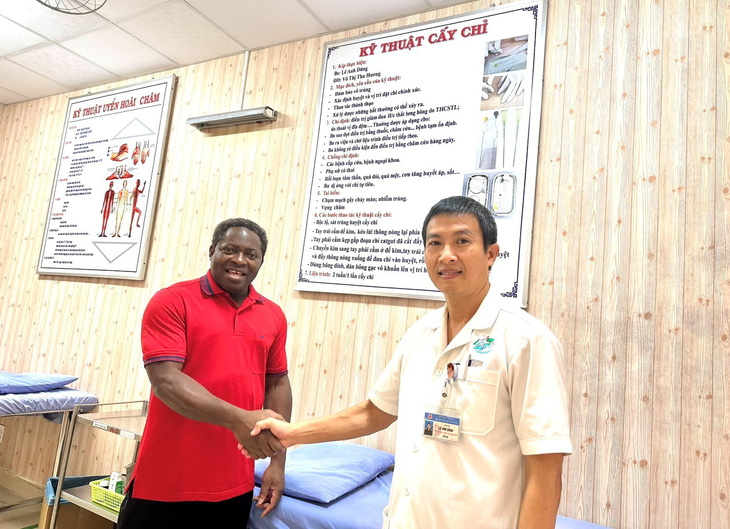 The patient (L) shakes hands with Doctor Le Anh Dung, head of the Traditional Medicine Department of Military Hospital 175 in Ho Chi Minh City. Photo: Supplied by Military Hospital 175