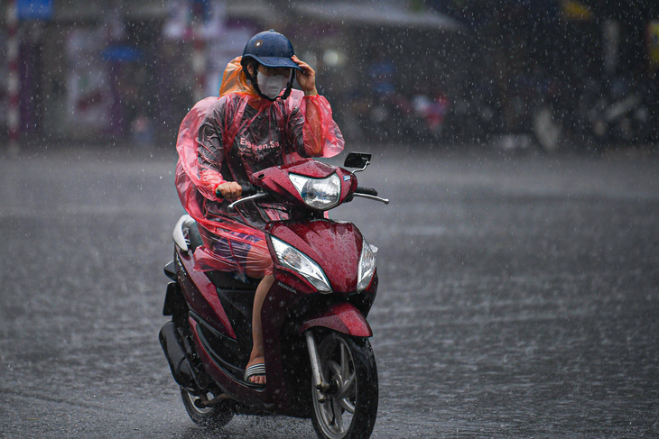 A commuter rides in the rain. Photo: Nam Tran / Tuoi Tre