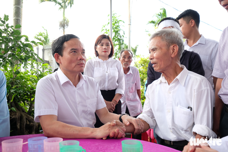 Vietnamese Deputy Prime Minister Tran Luu Quang (L) sends his deepest condolences to the father of Nguyen Van Dung, chairman of the People’s Committee of Ea Tieu Commune in Cu Kuin District, who were among the martyrs of the gun shootings on June 11, 2023. Photo: Mai Vinh / Tuoi Tre