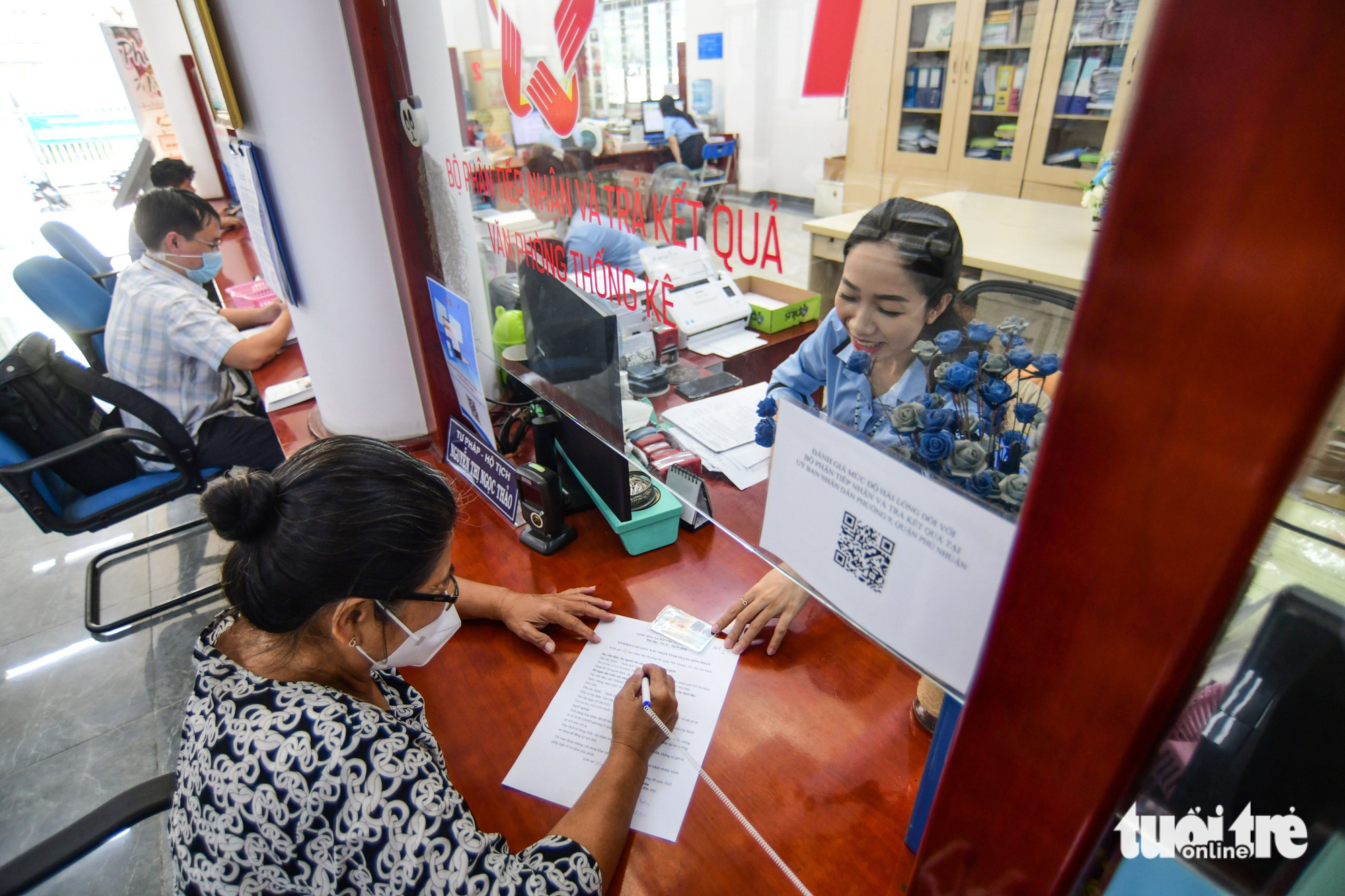 A QR code for cashless payment is stuck at the reception area in the headquarters of Ward 9 in Phu Nhuan District. Photo: Q. Dinh / Tuoi Tre