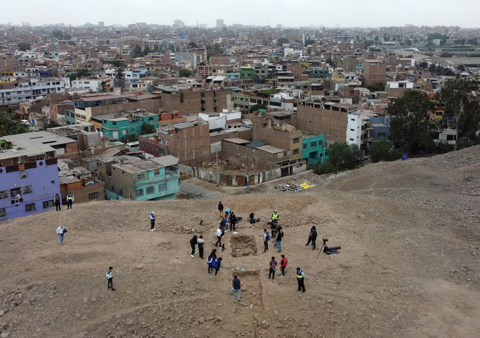 People stand near the excavation site of a pre-Hispanic burial with a mummy, believed to be from the Manchay culture which developed in the valleys of Lima between 1,500 and 1,000 BCE, in Lima, Peru, June 14, 2023. Photo: Reuters