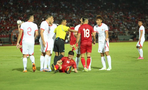 The referee books Hong Kong defender Helio Goncalves for bringing down Vietnamese midfielder Nguyen Quang Hai in the penalty area during their friendly match at Lach Tray Stadium in Hai Phong City, northern Vietnam, June 15, 2023. Photo: D.K. / Tuoi Tre