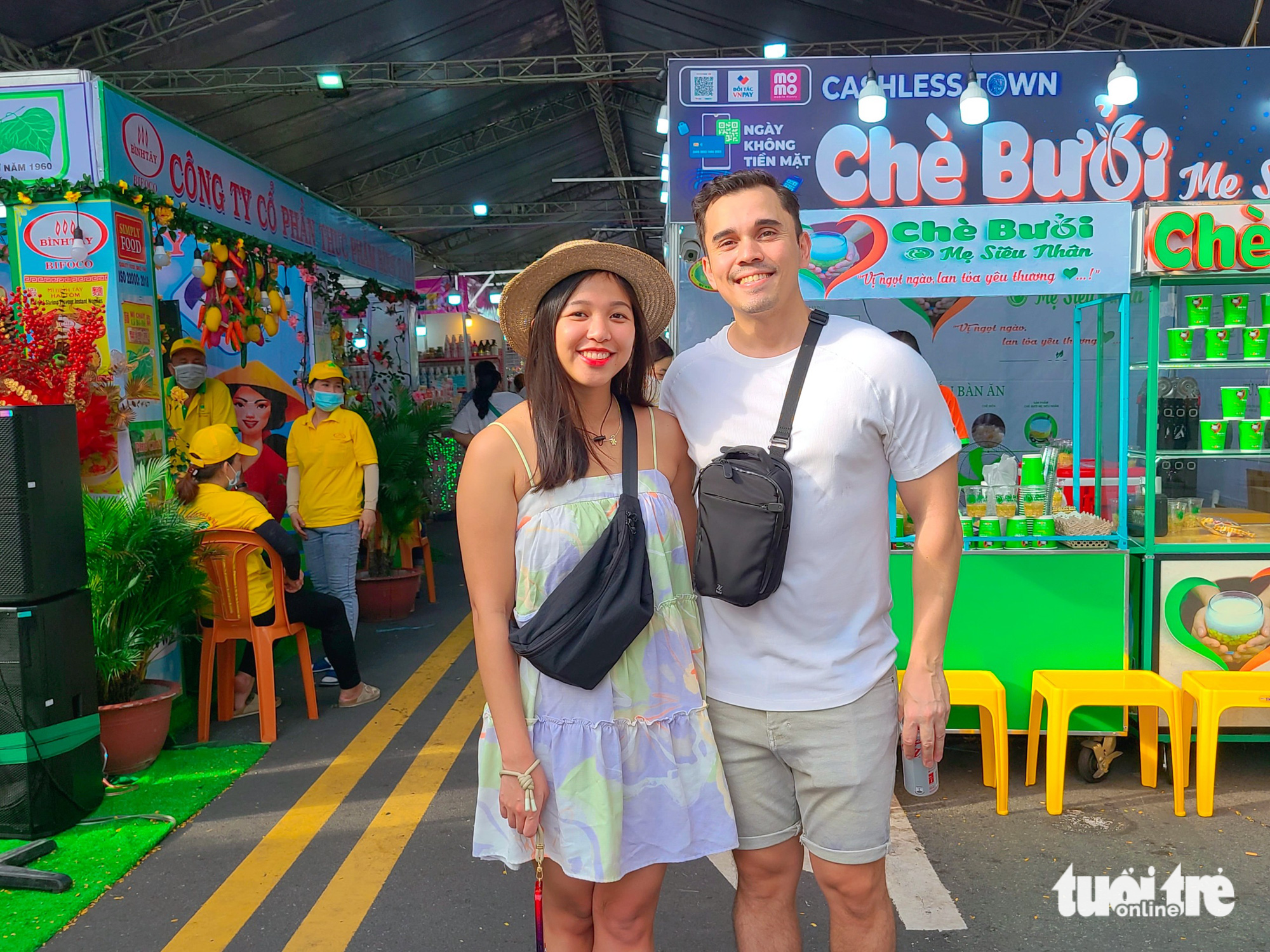 Kim Ricafort and Alex Aaltonen, a couple from Singapore, are seen in front of a Vietnamese sweet soup booth at the Cashless Festival in Ho Chi Minh City on June 16, 2023. Photo: Nhat Xuan / Tuoi Tre
