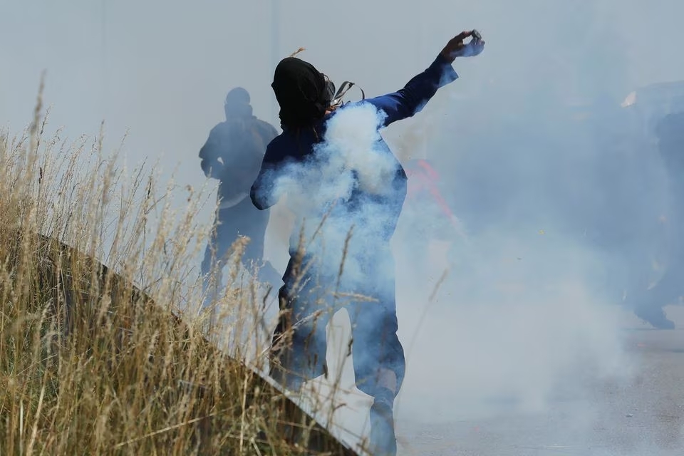 An activist throws an object, as they take part in a protest against the Lyon-Turin rail link between France and Italy, in Les Chavannes-en-Maurienne, France, June 17, 2023. Photo: Reuters