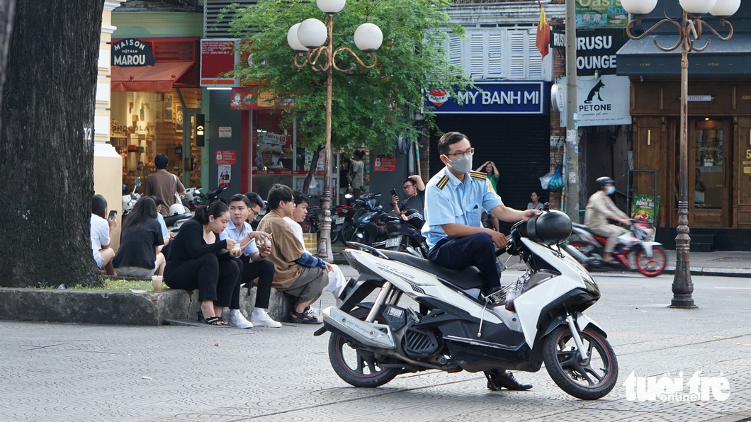 Young people sit under trees when they see an urban order management team. Photo: Tran Mac / Tuoi Tre