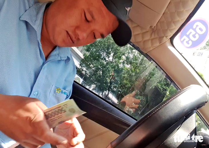 This screenshot captured from a video shows Minh charging a customer VND1.2 million ($51.1) for a 15.5-kilometer taxi service