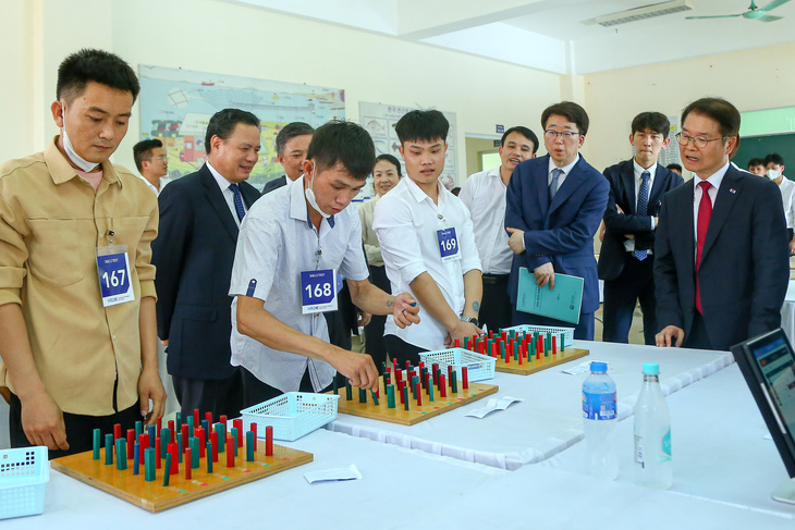 South Korean Minister of Employment and Labor Lee Jung Sik (R) sees Vietnamese candidates taking a test under the EPS program in Hanoi on June 21, 2023. Photo: Ha Quan / Tuoi Tre