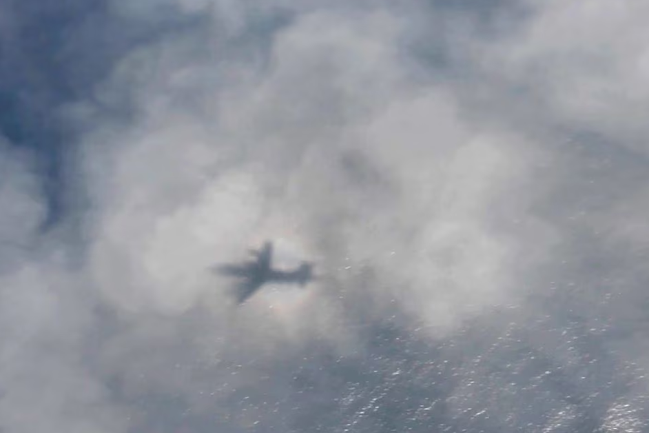 The shadow of a Royal Canadian Air Force CP-140 Aurora maritime surveillance aircraft of 14 Wing forms on cloud cover as it flies a search pattern for the missing OceanGate submersible, over the Atlantic Ocean off Newfoundland, Canada, June 20, 2023 in a still image from video. Photo: Reuters