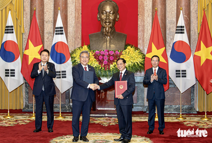 Vietnamese State President Vo Van Thuong (right, back row) and South Korean President Yoon Suk Yeol (left, back row) witness the signing by the two nations’ ministries of foreign affairs. Photo: Nguyen Khanh / Tuoi Tre