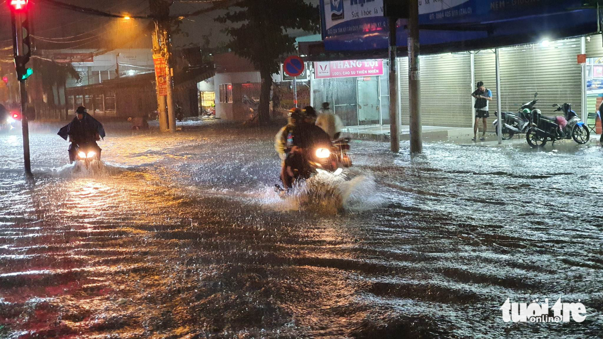 Motorcyclists travel on inundated Tan Ky Tan Quy Street in Ho Chi Minh City’s Tan Phu District on June 22, 2023. Photo: Minh Hoa / Tuoi Tre