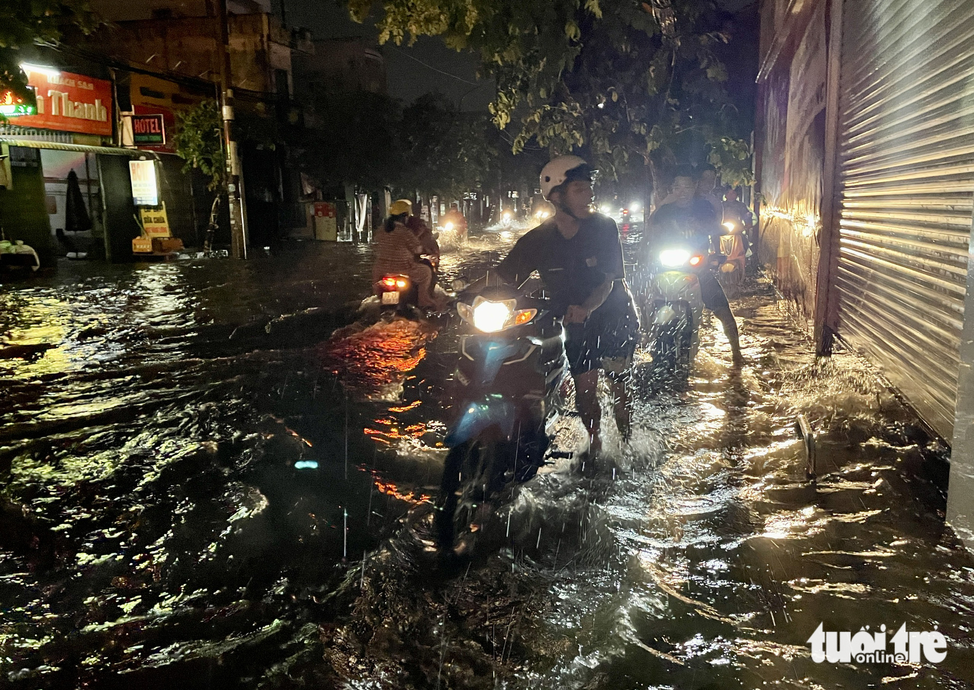 Motorcyclists wade through rainwater in Ho Chi Minh City on June 22, 2023. Photo: Chau Tuan / Tuoi Tre