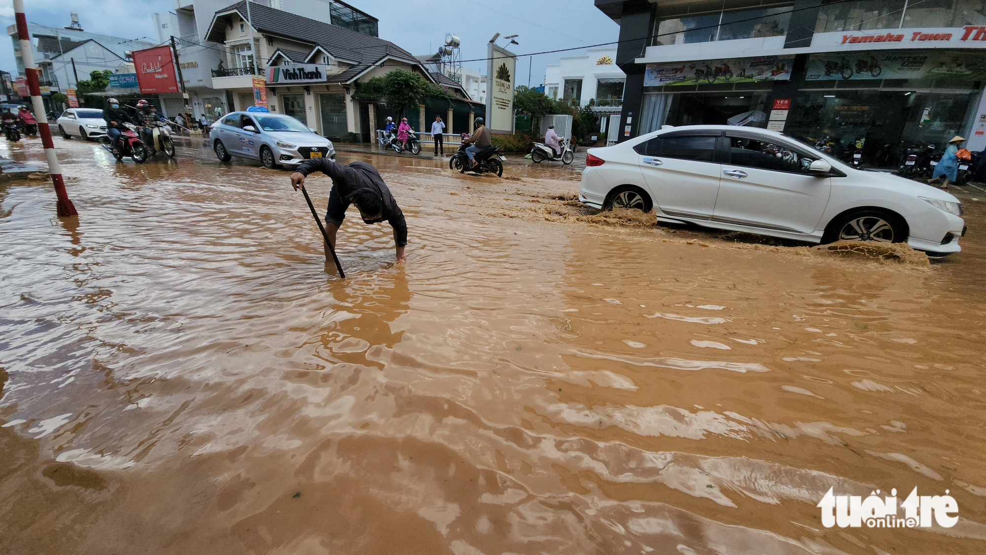 A local man clears a drainage hole on flooded Phan Dinh Phung Street in Da Lat City, located in Vietnam’s Lam Dong Province on June 23, 2023. Photo: M.V. / Tuoi Tre