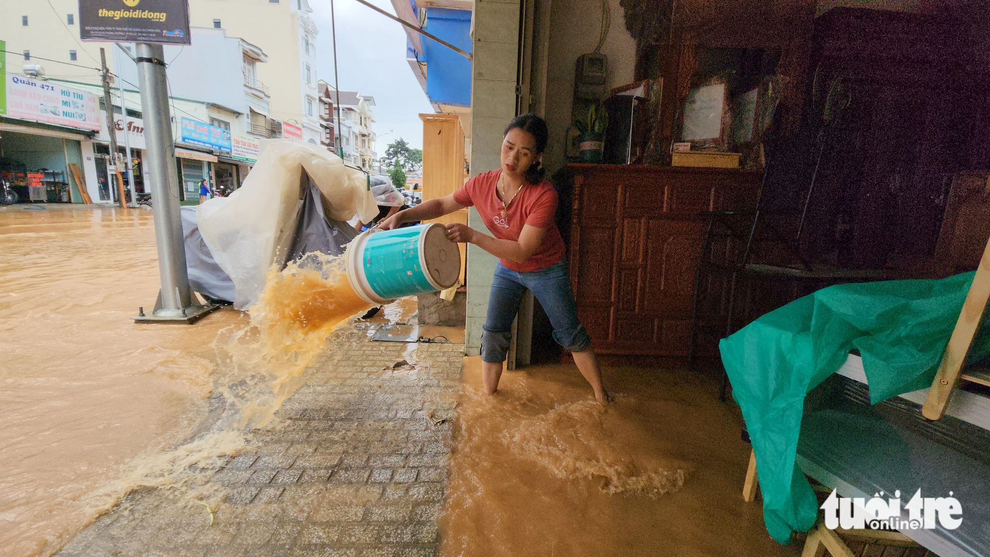 Nguyen Thi Mung, whose house is located on Phan Dinh Phung Street, cries when she is cleaning up her flooded house on June 23, 2023. Photo: M.V. / Tuoi Tre