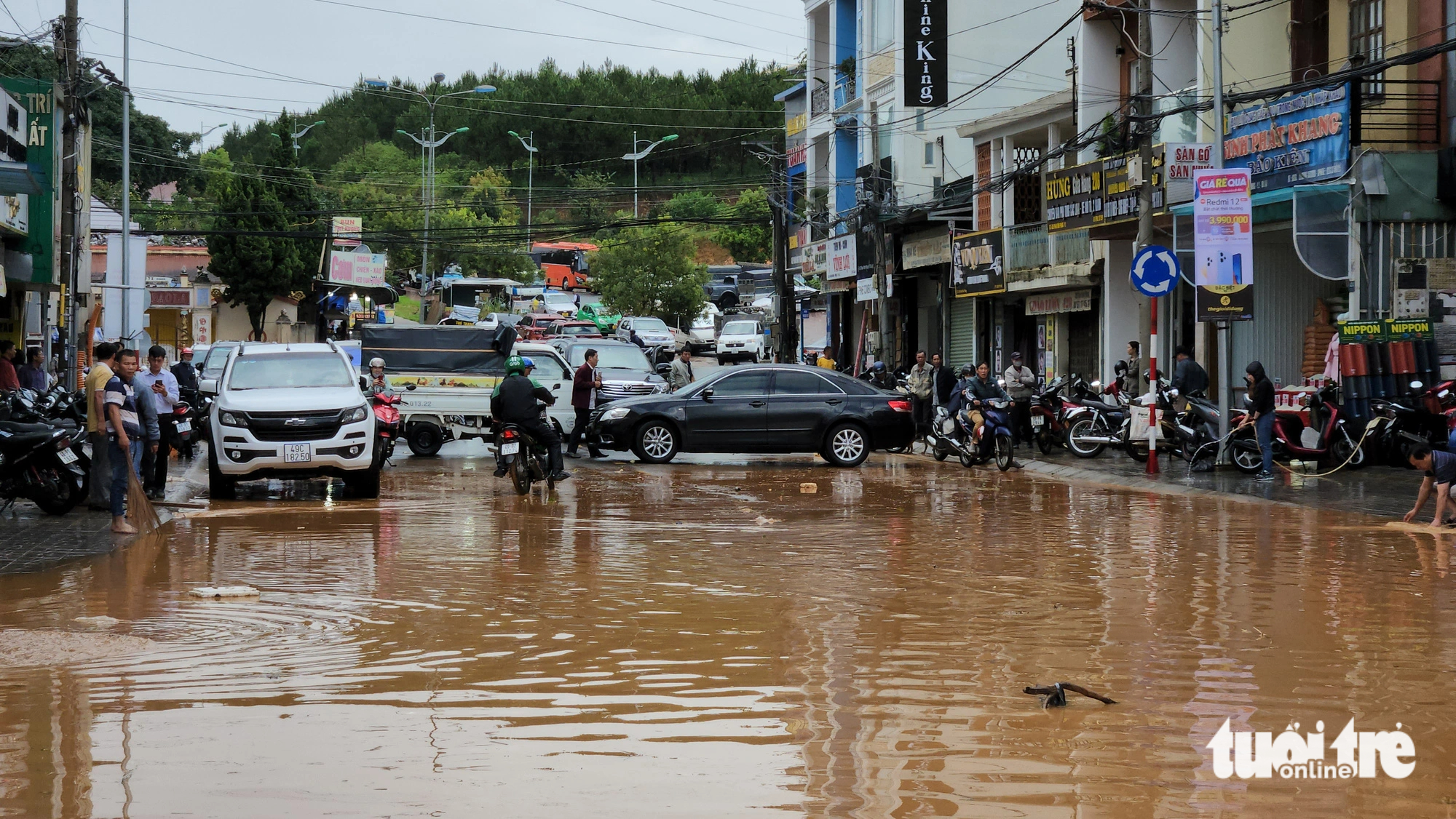Cars are used to block a flooded street in Da Lat City to prevent motorbikes from entering the route and experiencing possible accidents. Photo: M.V. / Tuoi Tre