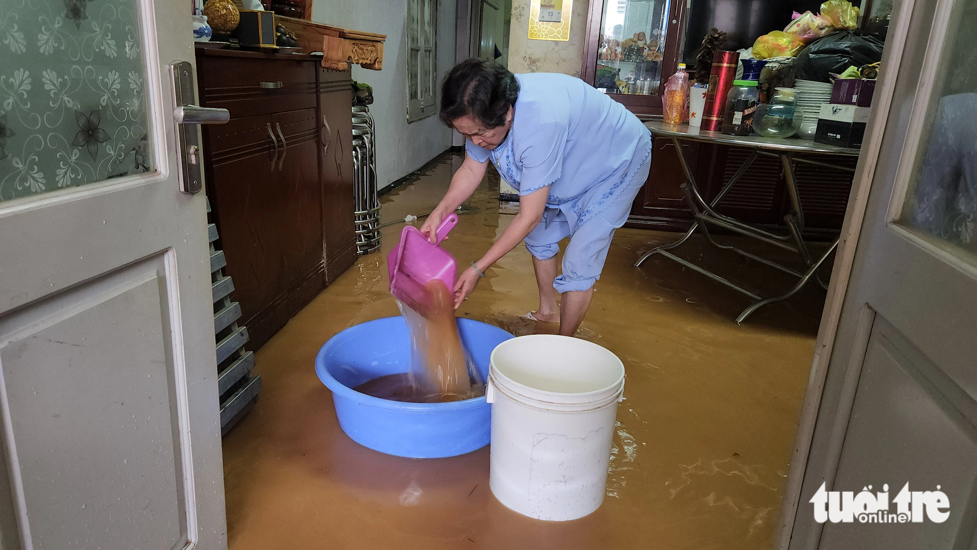 A local woman cleans up her flooded house after a heavy rain on June 23, 2023. Photo: M.V. / Tuoi Tre
