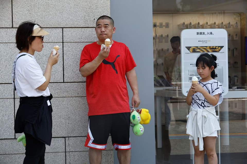 People eat ice cream amid a red alert for heatwave in Beijing, China June 23, 2023. Photo: Reuters
