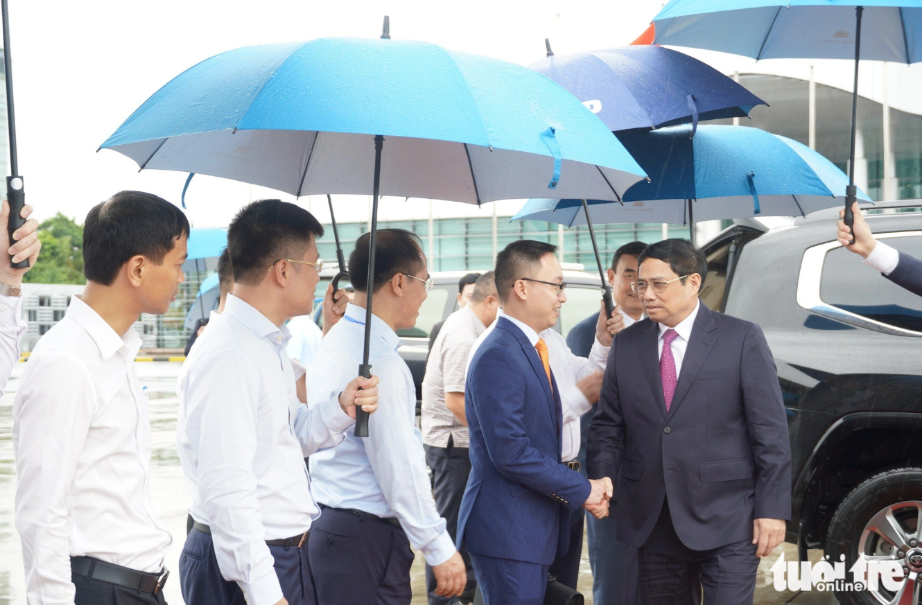 Prime Minister Pham Minh Chinh (first, right) shakes hands with an official at Noi Bai International Airport. Photo: Ngoc An / Tuoi Tre